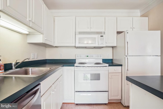 kitchen featuring white appliances, dark countertops, a sink, and white cabinetry