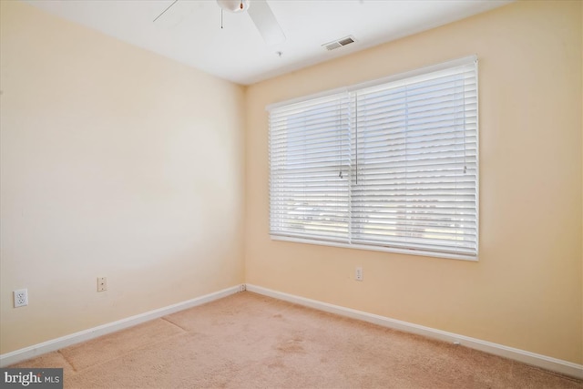 spare room featuring a ceiling fan, baseboards, visible vents, and carpet flooring