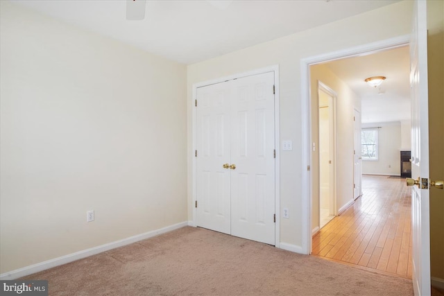 unfurnished bedroom featuring a closet, carpet, and baseboards