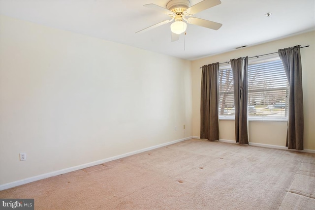 spare room featuring light carpet, visible vents, and baseboards