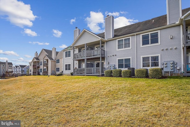 rear view of property with a lawn, a chimney, and a residential view