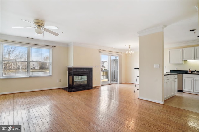 unfurnished living room featuring crown molding, light wood-type flooring, a sink, and a tile fireplace