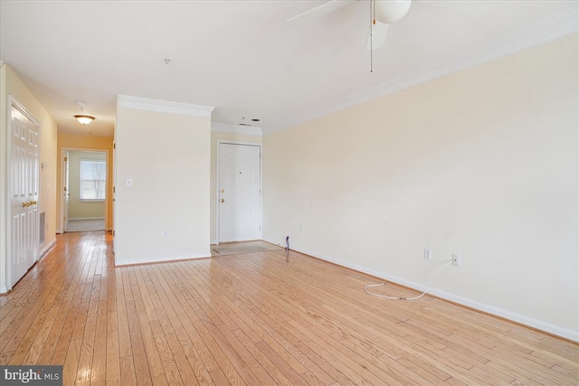 unfurnished room featuring baseboards, crown molding, and light wood finished floors