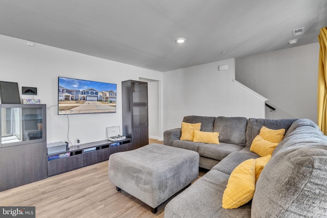 living room with recessed lighting, visible vents, and wood finished floors