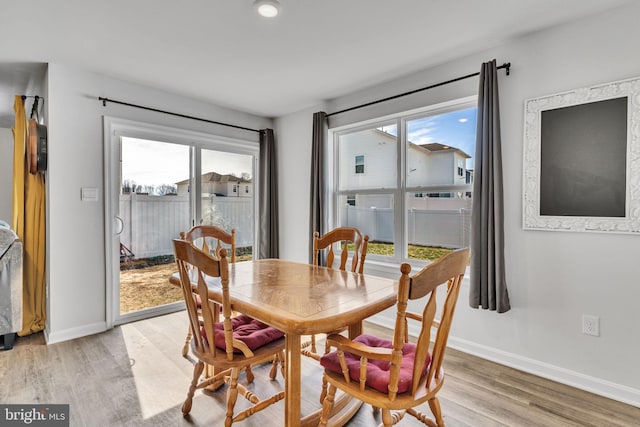 dining area featuring light wood-type flooring and baseboards