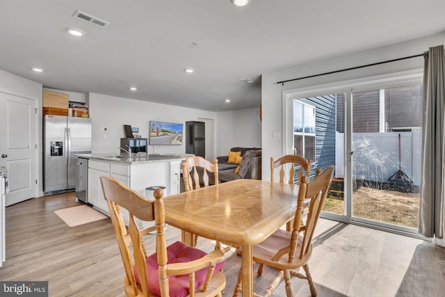 dining area featuring light wood finished floors, visible vents, and recessed lighting