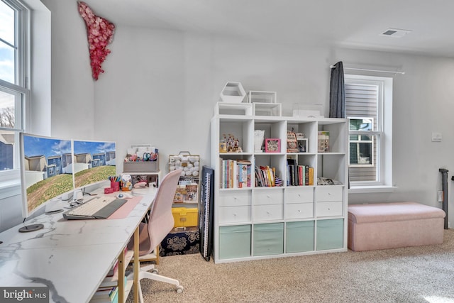 carpeted home office featuring visible vents and a healthy amount of sunlight