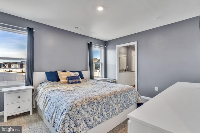 bedroom featuring light carpet and baseboards