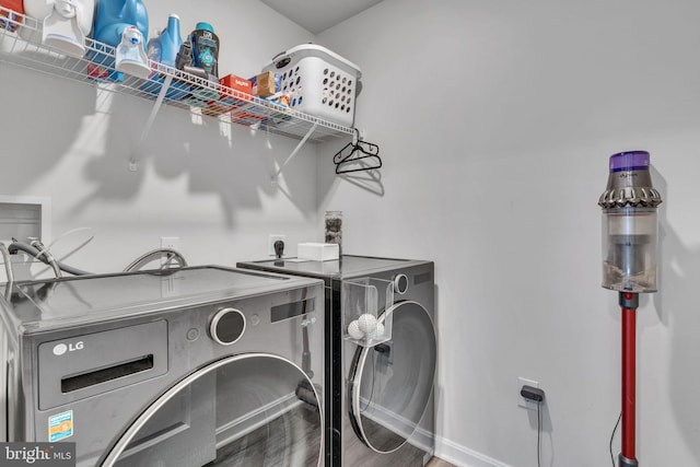 washroom featuring baseboards, independent washer and dryer, wood finished floors, and laundry area