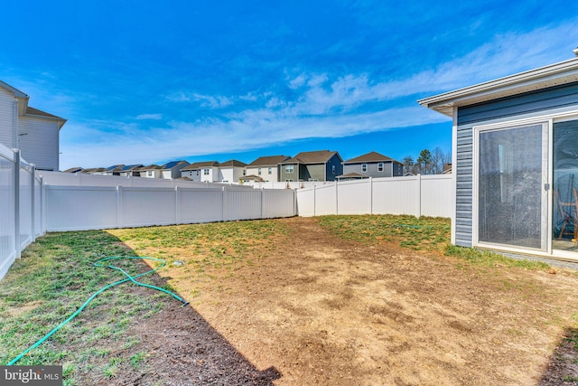 view of yard with a fenced backyard and a residential view