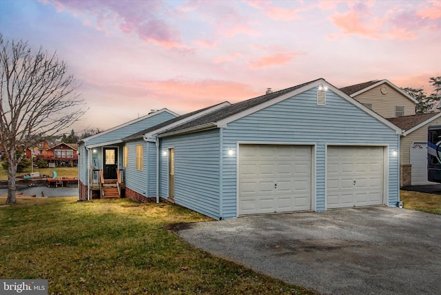 exterior space featuring a lawn, a garage, and driveway