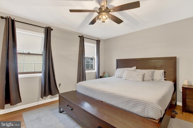 bedroom featuring ceiling fan, baseboards, and wood finished floors