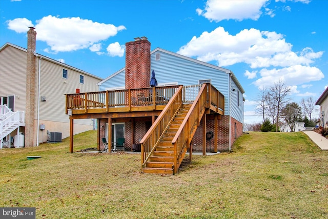 rear view of house with stairway, central AC unit, and a lawn