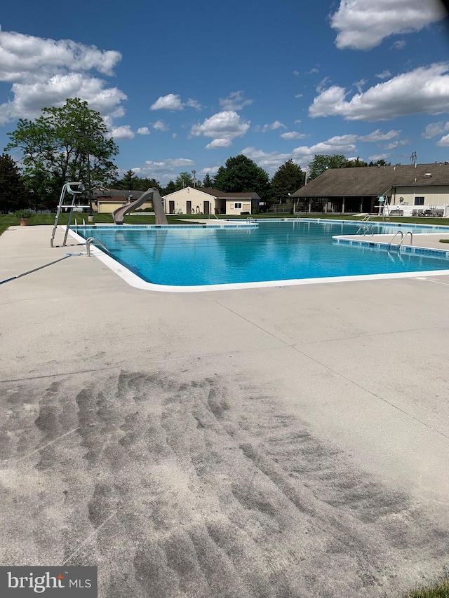 pool featuring a patio area and a water slide