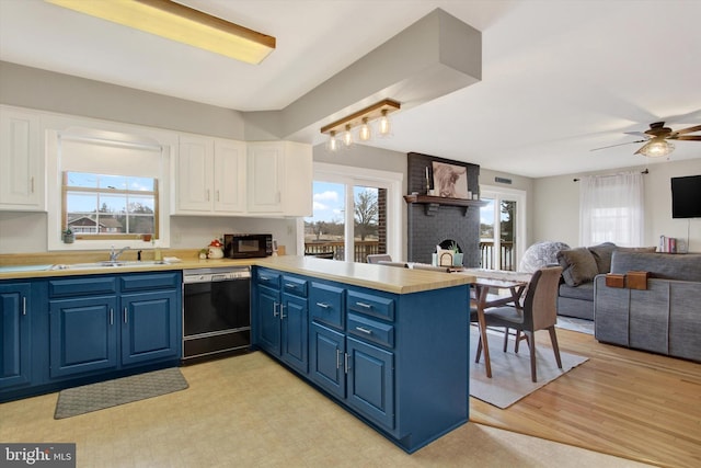 kitchen featuring blue cabinetry, white cabinetry, black appliances, and a peninsula