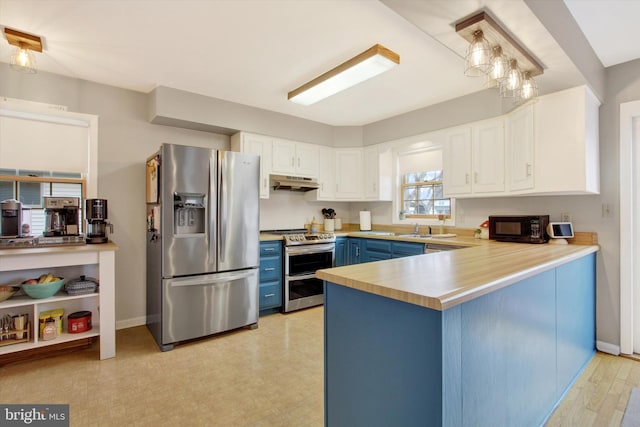 kitchen featuring a peninsula, stainless steel appliances, under cabinet range hood, white cabinetry, and blue cabinets