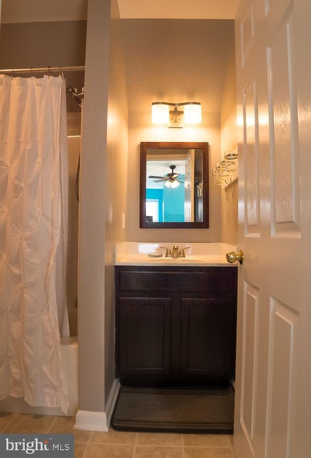 full bath with shower / tub combo with curtain, baseboards, vanity, and tile patterned floors