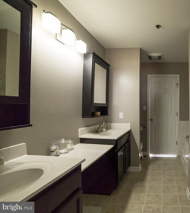 full bath featuring visible vents, a sink, a bath, and tile patterned floors