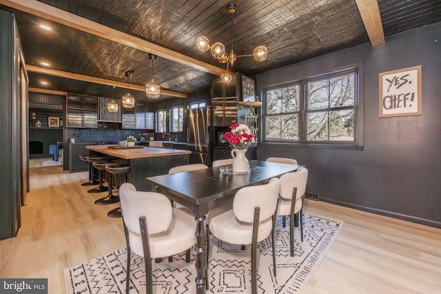 dining room featuring wooden ceiling, visible vents, baseboards, light wood finished floors, and beamed ceiling