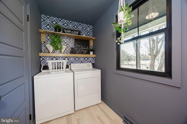 washroom with light wood-style flooring, laundry area, washer and clothes dryer, and baseboards