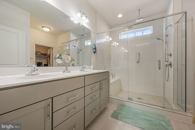 bathroom featuring double vanity, a stall shower, visible vents, tile patterned flooring, and a sink