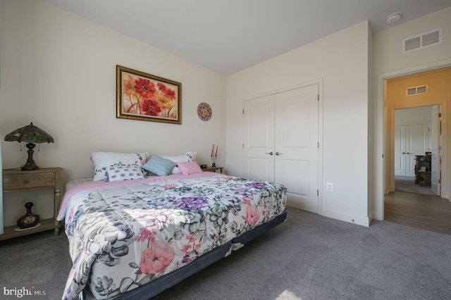 carpeted bedroom with a closet, visible vents, and baseboards