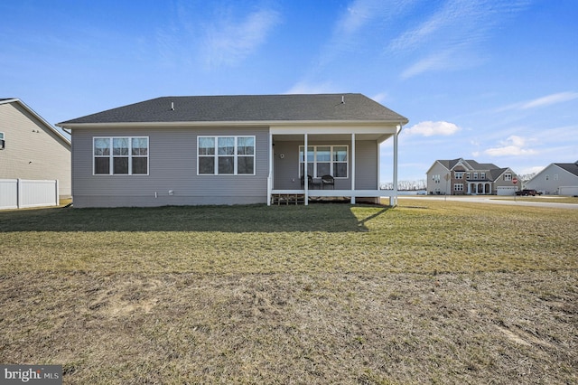 rear view of property featuring a lawn