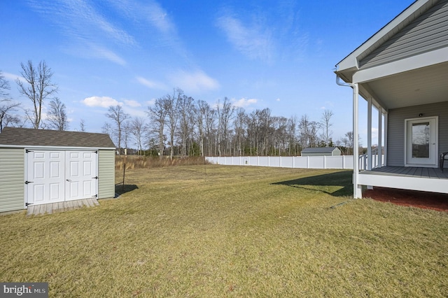 view of yard with an outdoor structure, a storage unit, and fence