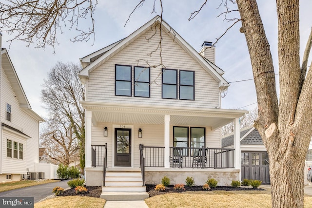 view of front of property featuring a porch, a chimney, and fence