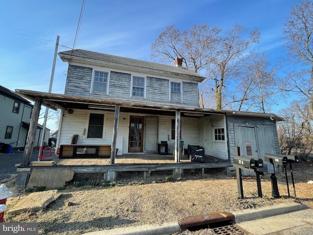 view of front of house with a chimney and a porch