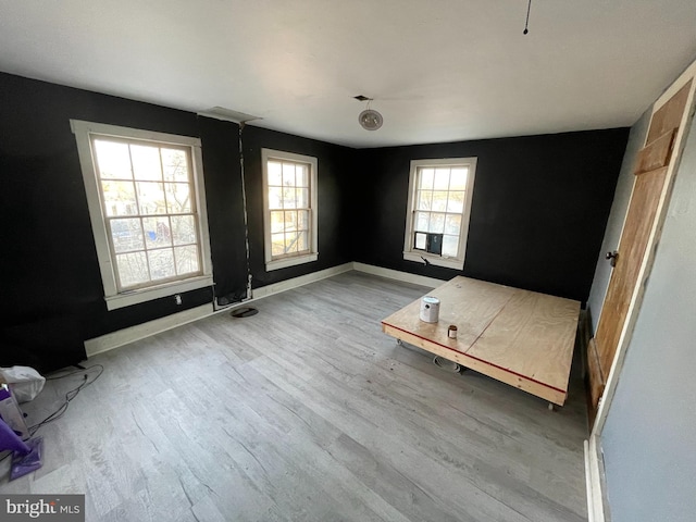 unfurnished bedroom featuring wood finished floors and baseboards