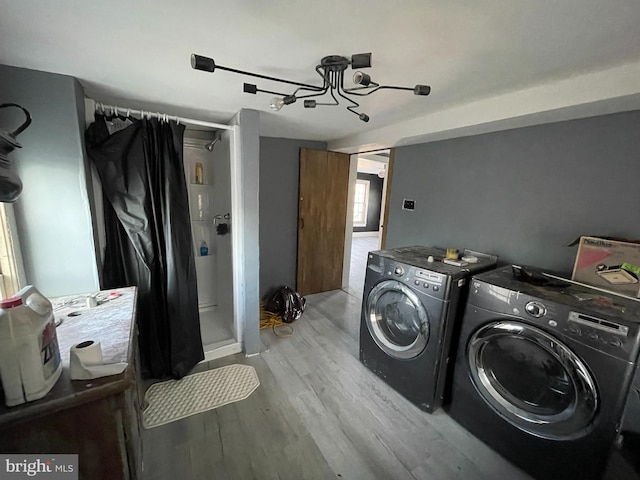 clothes washing area featuring laundry area, light wood-style flooring, and washing machine and dryer