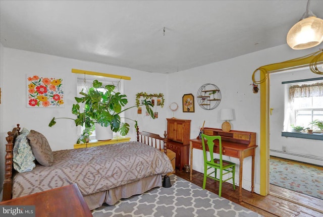 bedroom featuring a baseboard radiator and wood finished floors