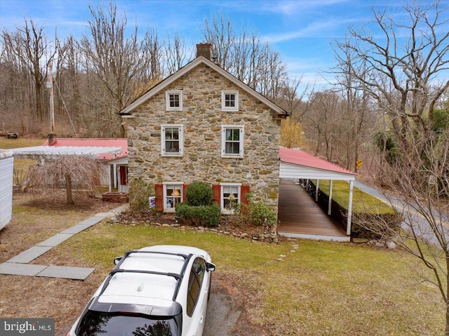 view of front facade with a chimney and a front yard