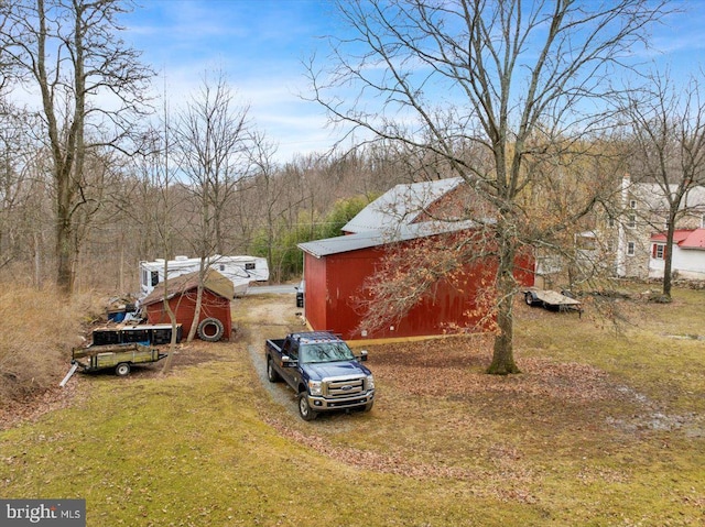 view of yard featuring an outbuilding, a barn, and driveway