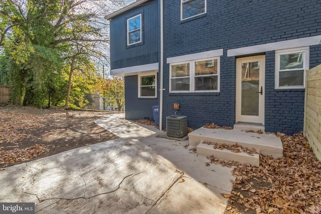 1354 Talbert Ter SE, Washington, DC 20020 - back of house featuring brick siding, central air condition unit, and a patio