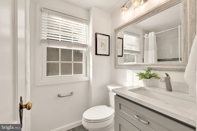 full bath featuring a shower with shower curtain, vanity, toilet, and baseboards