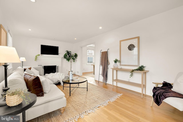 living area featuring recessed lighting, a fireplace, and light wood-style flooring