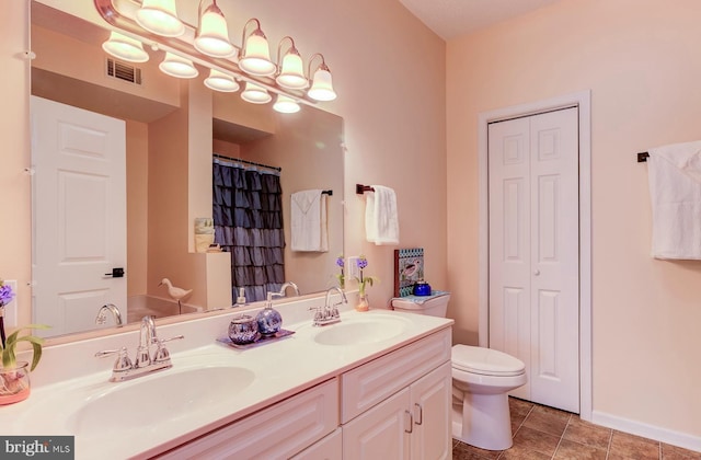 full bath featuring a closet, visible vents, a sink, and double vanity