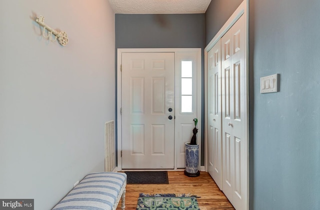 foyer entrance with a textured ceiling and wood finished floors