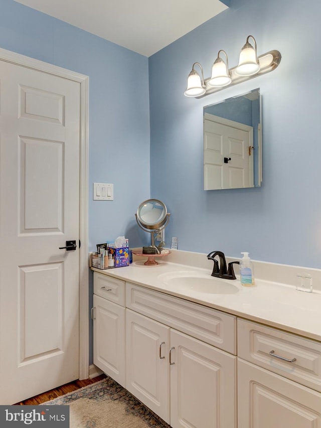 bathroom with wood finished floors and vanity