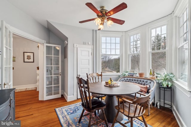 dining room with a ceiling fan, light wood-style flooring, and baseboards