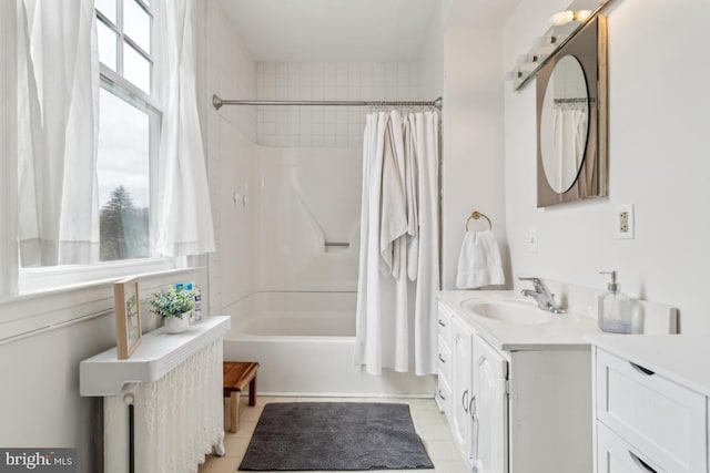 full bathroom featuring tile patterned flooring, shower / bath combo with shower curtain, and vanity