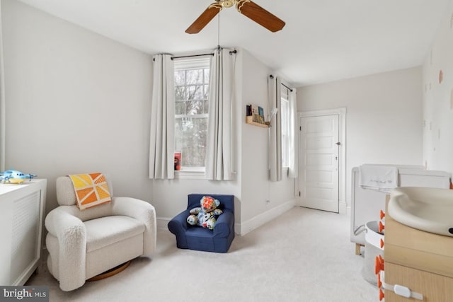 living area with carpet, ceiling fan, and baseboards