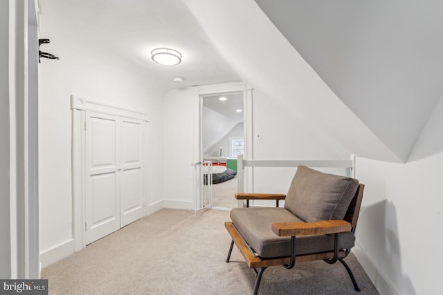 living area featuring lofted ceiling, carpet, and baseboards