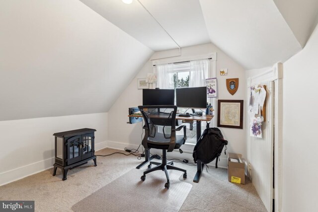 carpeted office space featuring lofted ceiling and baseboards