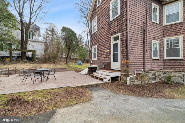 view of side of home with a patio area, fence, and cooling unit