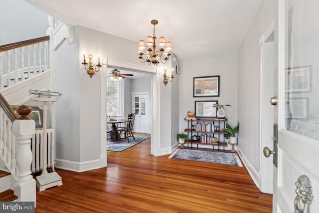 foyer with radiator, hardwood / wood-style flooring, baseboards, and stairs