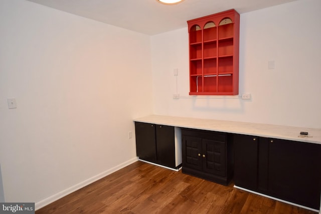 interior space with built in desk, wood finished floors, and baseboards