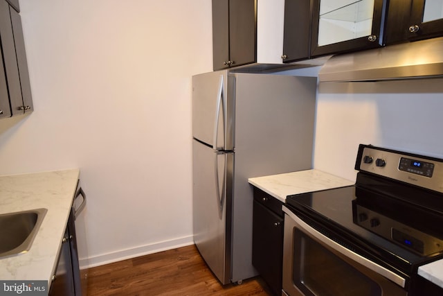 kitchen featuring under cabinet range hood, dark wood-style flooring, baseboards, electric stove, and freestanding refrigerator